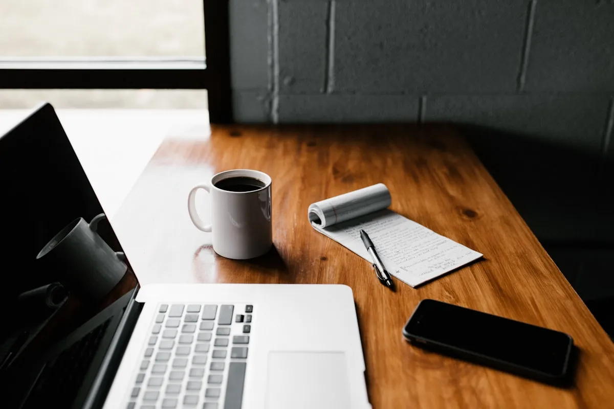 Clean workspace with notebook and laptop representing simple project planning